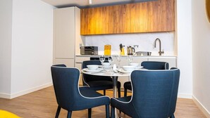 A modern kitchen with a dining area, featuring a microwave, kettle, and a sink. - Birmingham City Retreat No 117 (Birmingham)