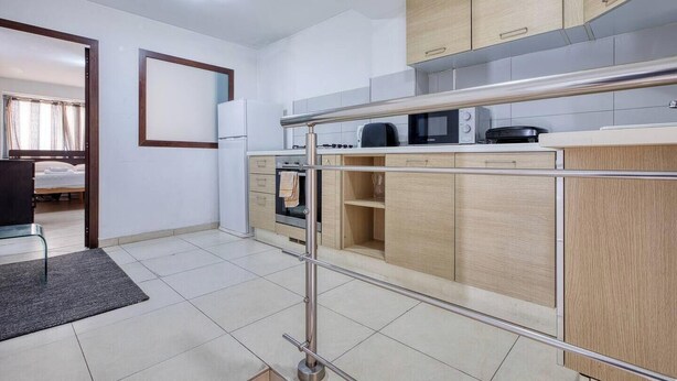A modern kitchen with a microwave, oven, and stainless steel appliances. - Sliema Central 1BR Apt | Own Entrance, Walk to Sea (Tas-Sliema)