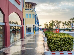 A building with a yellow facade, a red archway, and a blue staircase. - Cozy Studio with Pool - The Strip street & Beach (Albufeira)