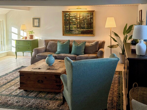 A living room with a brown sofa, blue armchair, and a wooden coffee table.