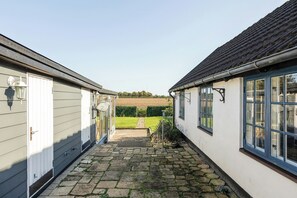 A narrow pathway leading to a house with a tiled roof and white walls. - Half-timbered cottage near Knuthenborg Park (Maribo)