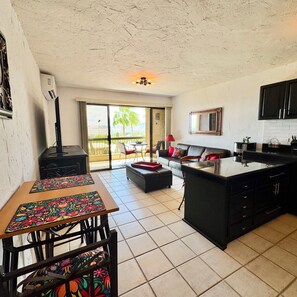 A kitchen with a dining area, a large window, and a view of palm trees. - Casa Hayley - 1 bedroom in Cabo San Lucas with arch views, heated pool & AC (Cabo San Lucas)