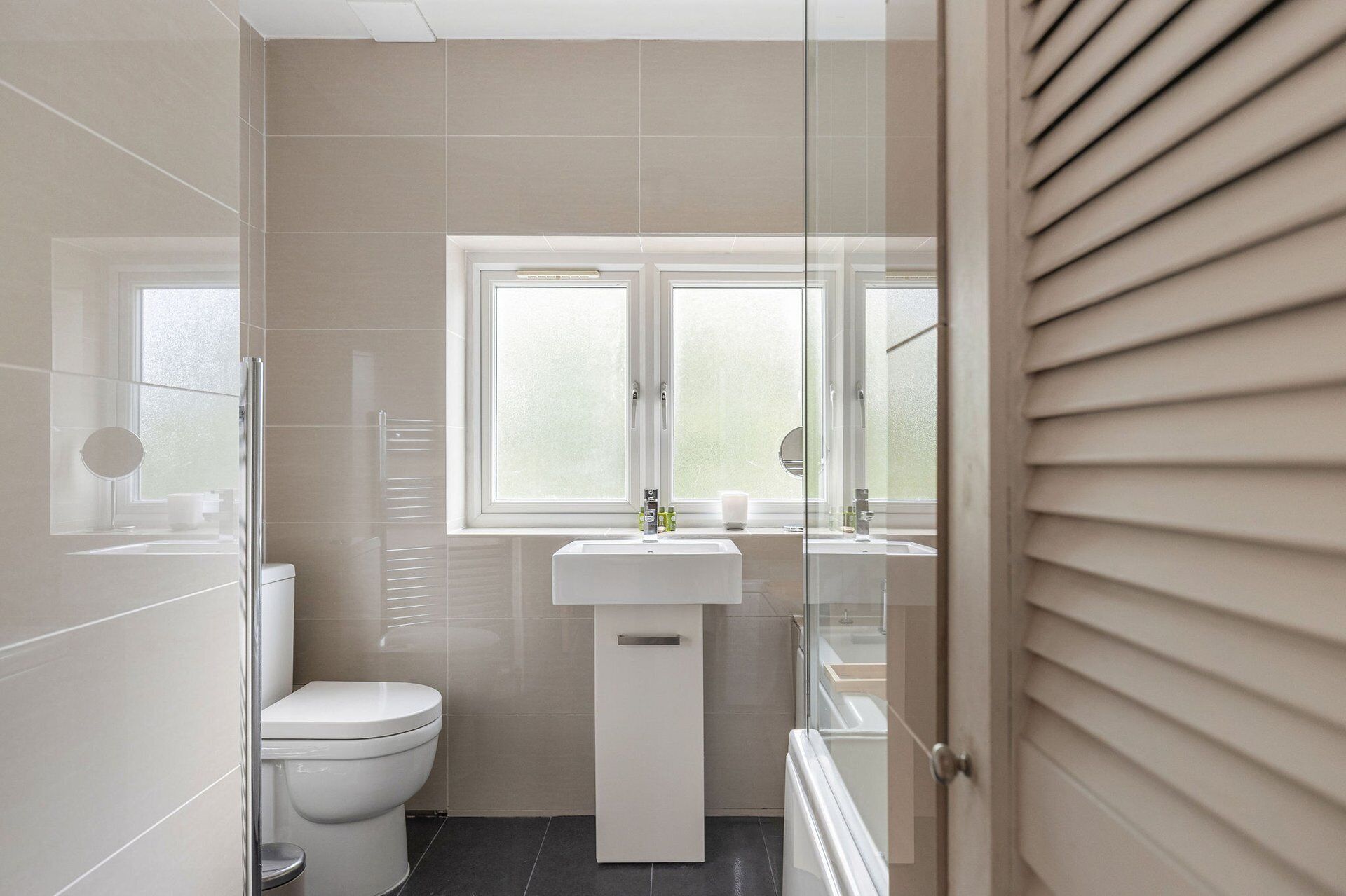 A bathroom with a toilet, a sink, and a glass shower enclosure.