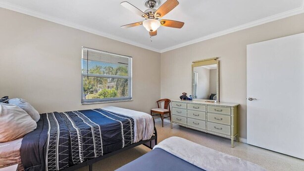 A bedroom with two beds, a dresser, a ceiling fan, and a window with blinds. - 2BR 2BA Updated Beach Apt with Screened Patio (West Palm Beach)