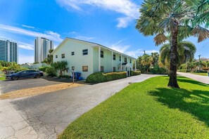 A two-story building with a flat roof, a parking lot, and a well-maintained lawn. - 2BR 2BA Updated Beach Apt with Screened Patio (West Palm Beach)