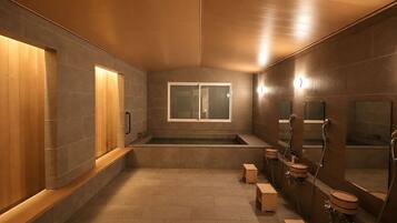 A modern bathroom with a wooden vanity, a large mirror, and a bathtub.