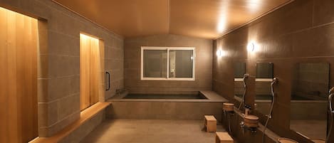 A modern bathroom with a wooden vanity, a large mirror, and a bathtub.