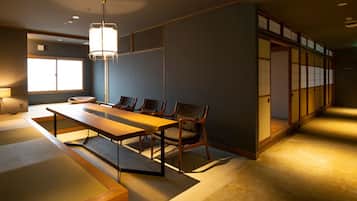 A traditional Japanese room with tatami flooring, a low table, and chairs.