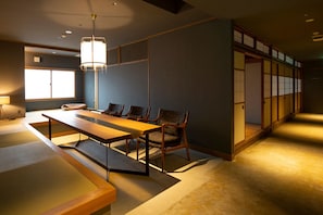 Una habitación japonesa tradicional con suelo de tatami, una mesa baja y sillas.