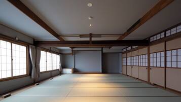A traditional Japanese room with tatami flooring, sliding doors, and a low ceiling.