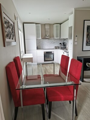 A modern kitchen with white cabinets, a built-in oven, and a coffee maker.