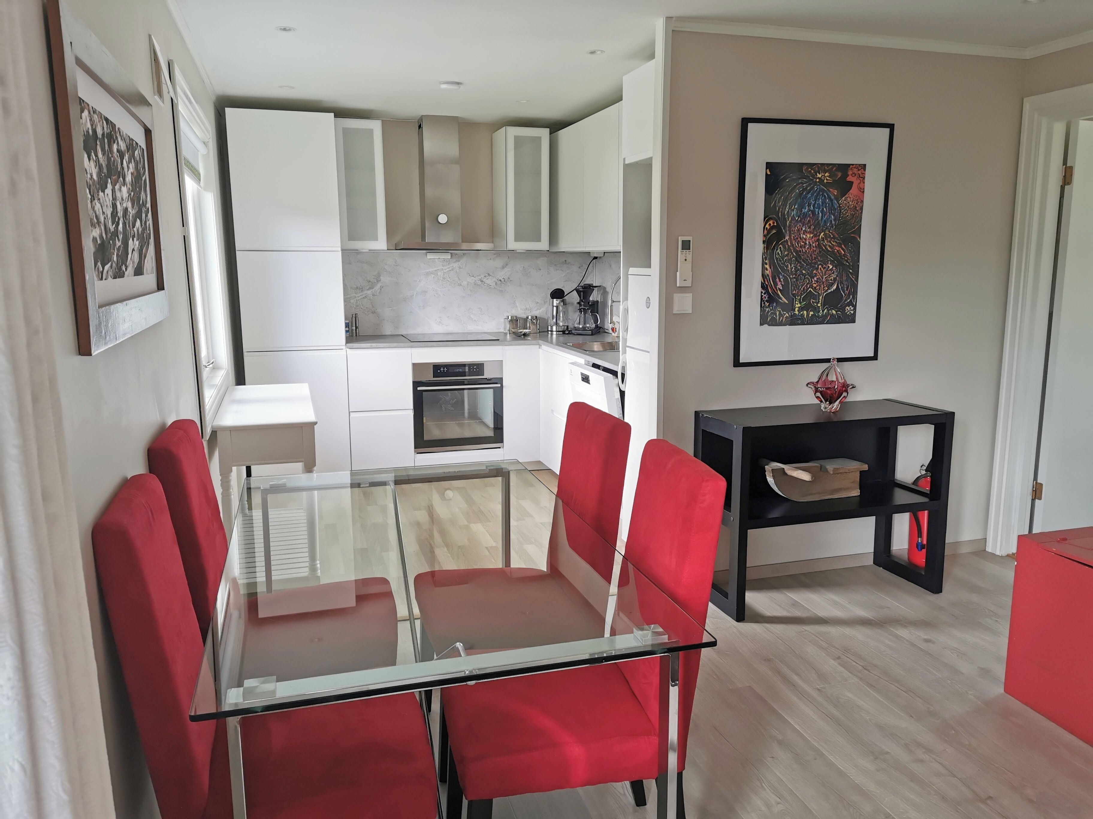 A modern kitchen with white cabinets, a built-in oven, and a coffee maker.
