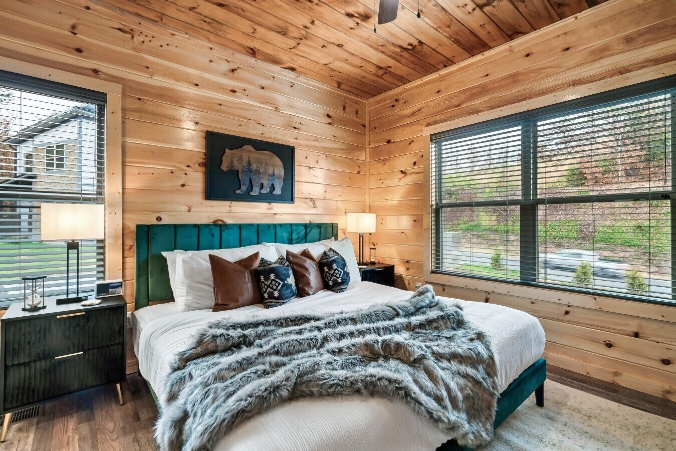 A wooden cabin bedroom with a bed, pillows, a headboard, and two bedside tables.