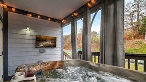 Una vasca idromassaggio con un pontile in legno e un quadro al muro.
