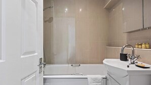 Ein modernes Badezimmer mit einer Badewanne, einem Waschbecken und einer Dusche.