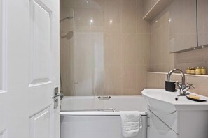 Ein modernes Badezimmer mit einer Badewanne, einem Waschbecken und einer Dusche.