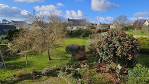 En velholdt have med forskellige planter og en stor blomstrende busk.