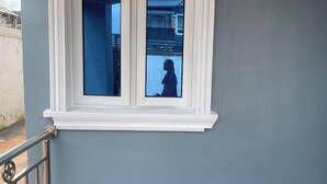 Una escalera con barandilla de metal y una ventana con marco blanco.
