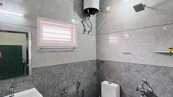 Un baño con lavabo, inodoro, ducha y un ventilador en el techo.