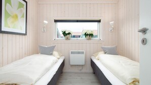Una habitación con dos camas, una ventana y vistas, y un radiador.