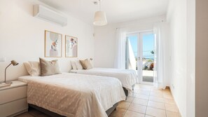 A hotel room with two beds, a nightstand, a lamp, and a ceiling fan. - CASA VISTA MAR - Lagos / Algarve - A stunning vacation home for up to 6 people (Lagos)