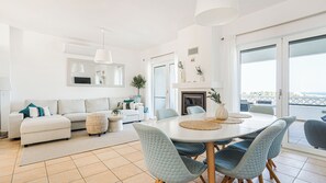 A modern living room with a sofa, coffee table, and chairs. There is a fireplace and a large window with a view. - CASA VISTA MAR - Lagos / Algarve - A stunning vacation home for up to 6 people (Lagos)