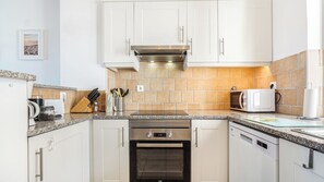 A modern kitchen with white cabinets, a built-in oven, microwave, and a coffee machine. - CASA VISTA MAR - Lagos / Algarve - A stunning vacation home for up to 6 people (Lagos)