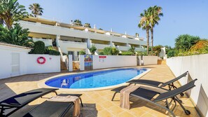 A swimming pool with lounge chairs and a lifebuoy, surrounded by a white building with balconies and palm trees. - CASA VISTA MAR - Lagos / Algarve - A stunning vacation home for up to 6 people (Lagos)