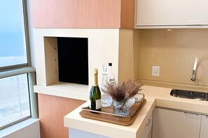 A modern kitchen with a built-in wine cooler, a wine bottle, and a decorative vase. - ASA Apto Vale Dourado Frente-mar Hidro 2vgs (Balneário Camboriú)