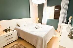 Ein aufgeräumtes Schlafzimmer mit einem Bett, Nachttischen, einer Lampe und einem dekorativen Gegenstand.