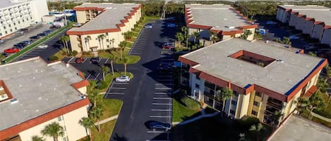 Um hotel à beira-mar com vários edifícios, parques de estacionamento e vista para o oceano.