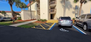 A parking area with handicapped accessible spaces, a building entrance, and a clear sky. - Steps from the Ocean - St Augustine Beach Retreat (Saint Augustine Beach)