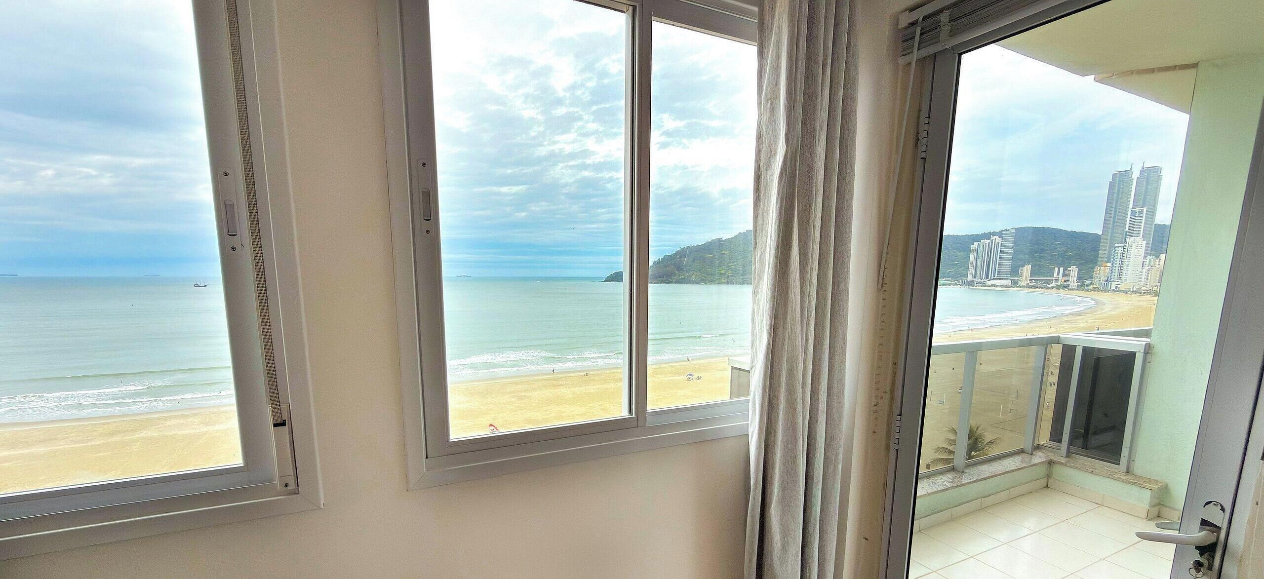 A balcony with a view of a beach and cityscape.