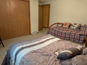 A bedroom with a large bed, a wooden wardrobe, and a door leading to another room. - 3-bedroom family-friendly country home in Galena with air conditioning (Galena)