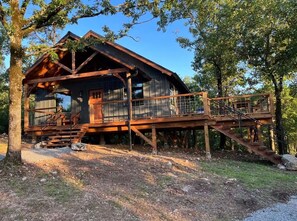 Eine Holzhütte mit einer Terrasse und Treppen zu einer überdachten Veranda.