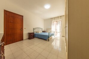 Ein Schlafzimmer mit Bett, Schminktisch, Heizkörper und Tür.