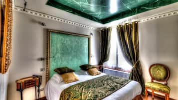 A bedroom with a large bed, a chair, and a window with curtains.