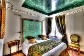 Ein Schlafzimmer mit einem großen Bett, einem Sessel und einem Fenster mit Vorhängen.
