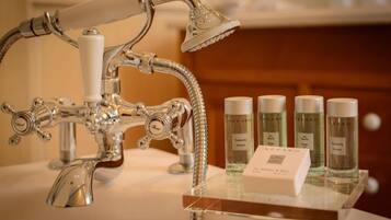 A bathroom with a vintage-style shower and a display of Azzaro brand toiletries.