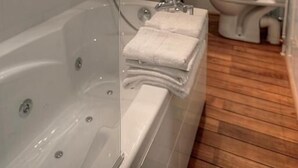 Un baño moderno con ducha envuelta en vidrio, bañera, lavamanos e inodoro.