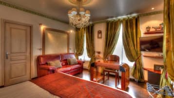 Ein Hotelzimmer mit einem großen Bett, einem roten Ledersofa, einem Holztisch und einem Fernseher.