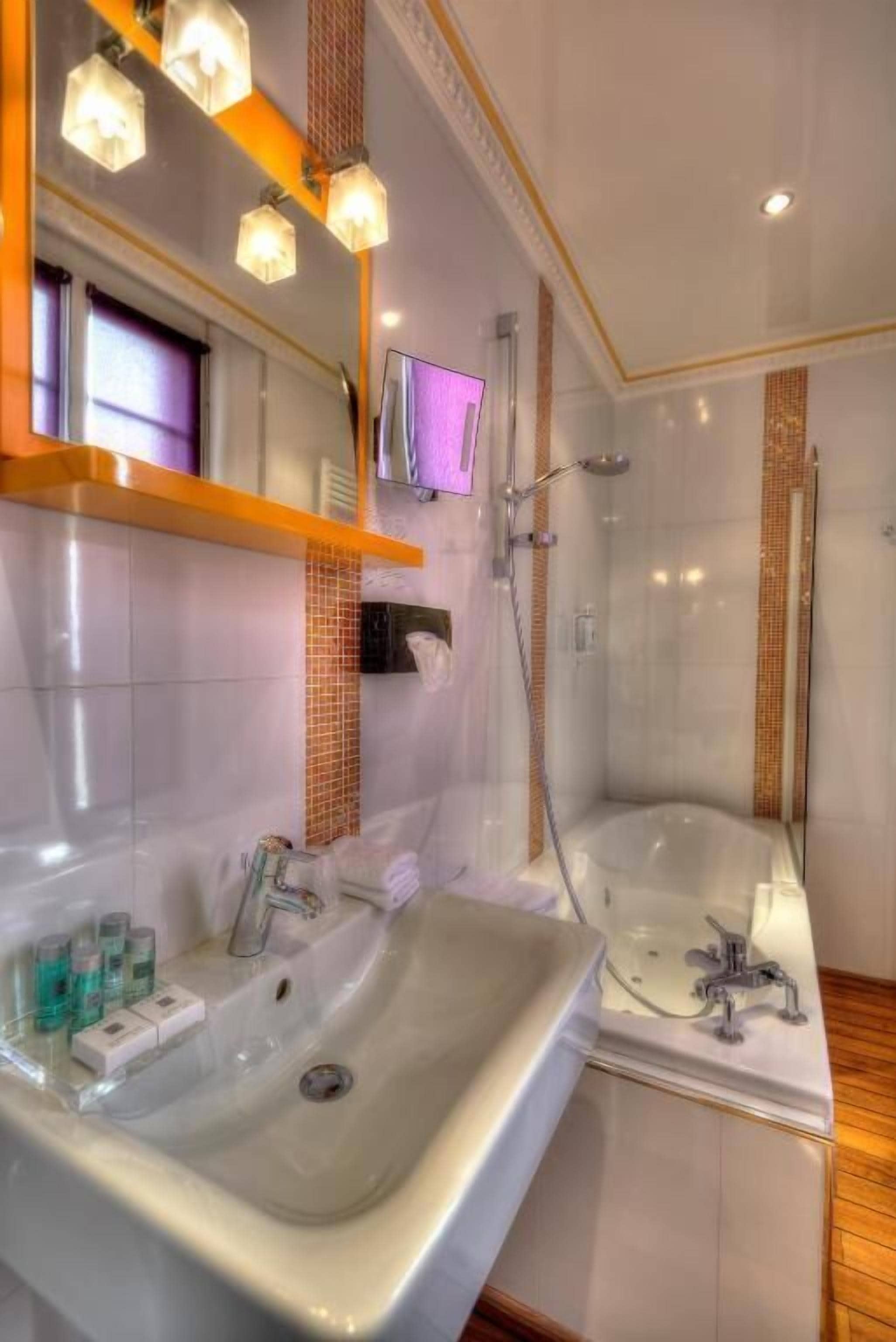 A modern bathroom with a large bathtub, a separate shower area, and a vanity with a sink.
