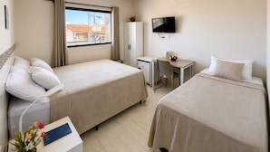 A hotel room with two beds, a desk, a TV, and a window with curtains. - Pousada Brumar Maragogi (Maragogi)