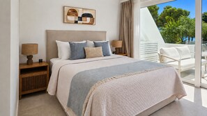 A bedroom with a bed, bedside tables, a window with curtains, and a view of the outdoors. - Beautiful apartment with pool & sea views (Mijas Costa)