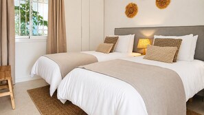 A double bed with a grey headboard, beige bedding, and a bedside table with a lamp. - Beautiful apartment with pool & sea views (Mijas Costa)