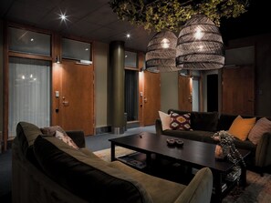 Ein modernes Wohnzimmer mit einer Sofagarnitur, einem Couchtisch und einer Zierpflanze.