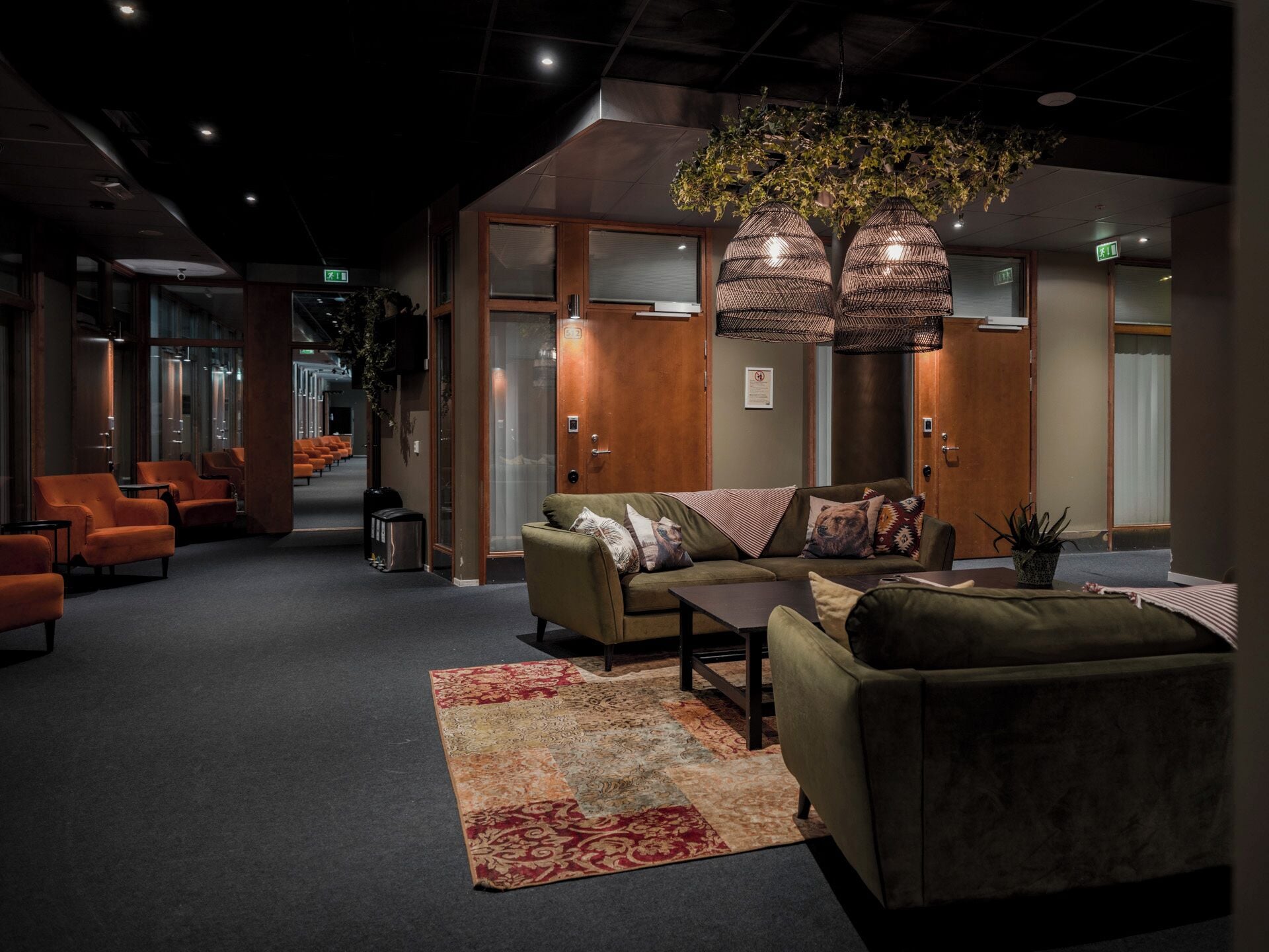 A lobby with a sofa, chairs, a coffee table, and a patterned rug.