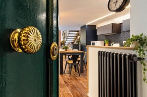 A modern kitchen with a dining area, a radiator, and a clock on the wall. - Luxury Loft in Campo de' Fiori (Roma)