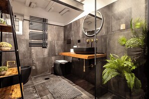 A modern bathroom with a black sink, wooden vanity, and a large mirror. - Luxury Loft in Campo de' Fiori (Roma)