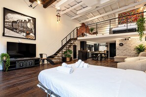 A spacious loft-style bedroom with a large bed, a dining area, and a kitchen. - Luxury Loft in Campo de' Fiori (Roma)